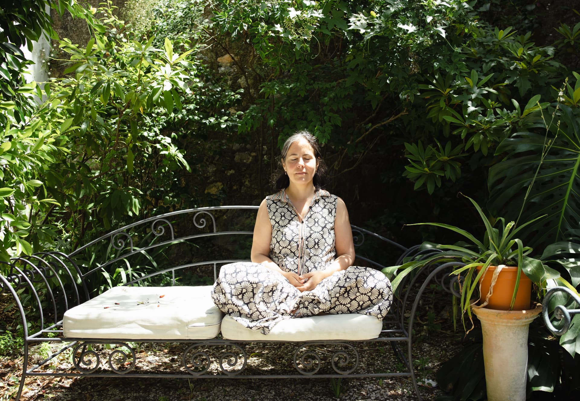 Dr. Aleksandra Matakovic-Manca sitting in meditation in a garden